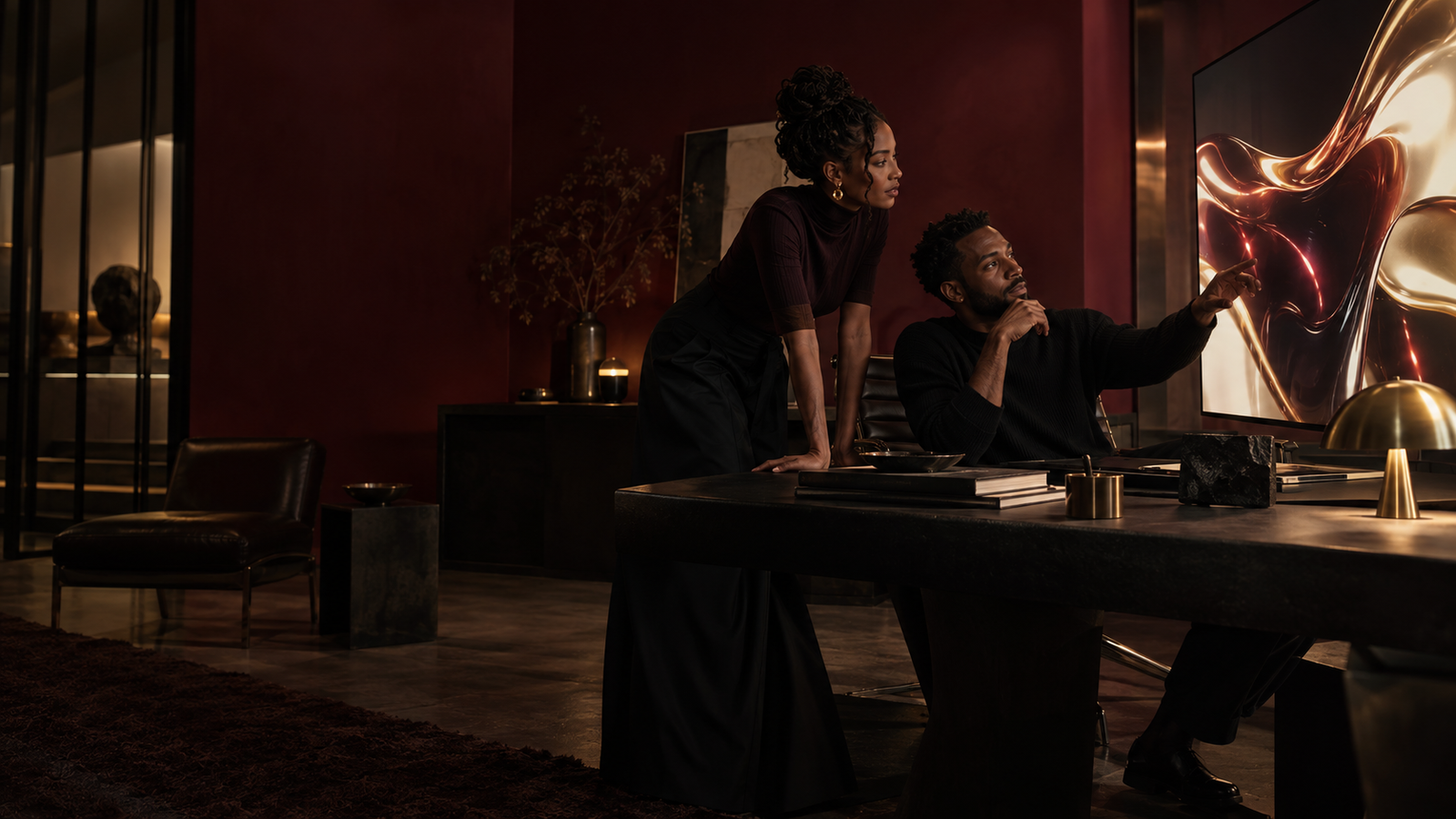 Two creative professionals collaborating in a wine-red design studio